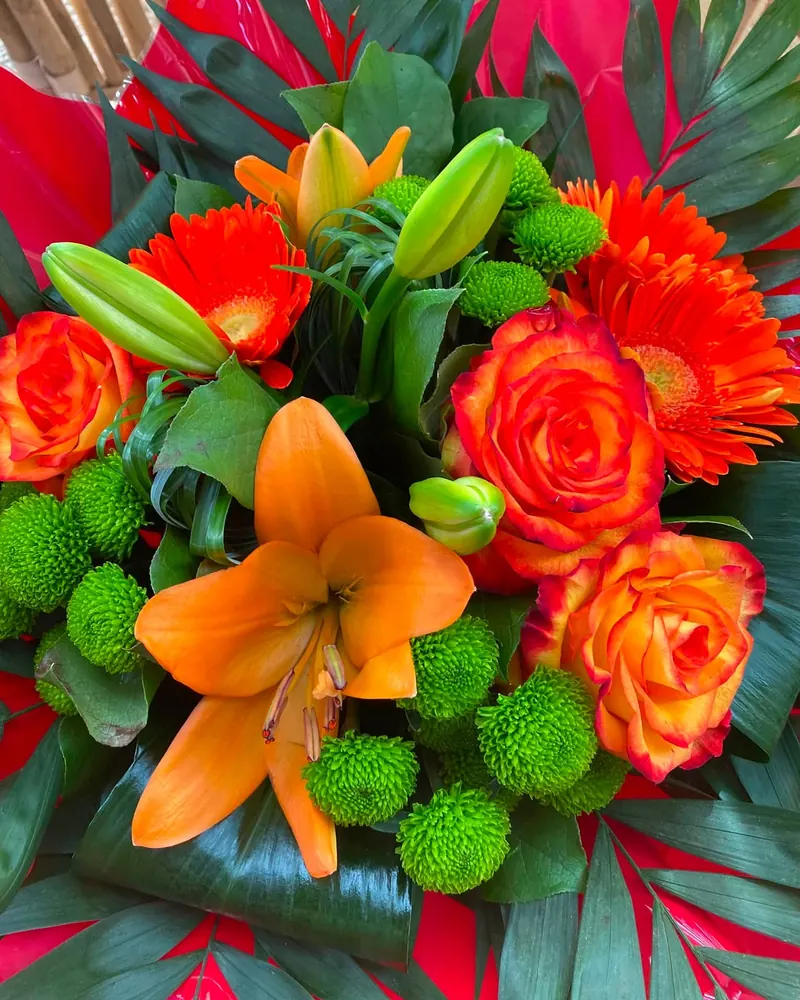 Bouquet coloré composé de lys orange, roses et gerberas à La Serre de Claire